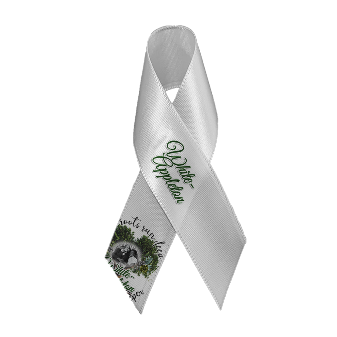 White satin memorial ribbon with safety pin, featuring White-Appleton lineage photo and tree-root design.