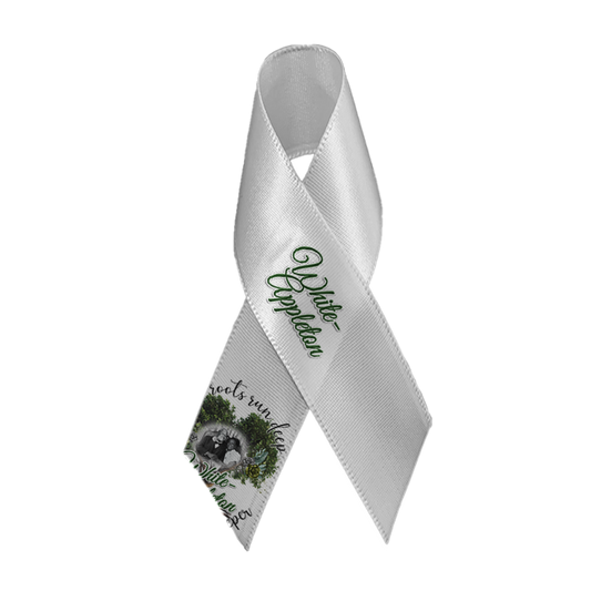White satin memorial ribbon with safety pin, featuring White-Appleton lineage photo and tree-root design.